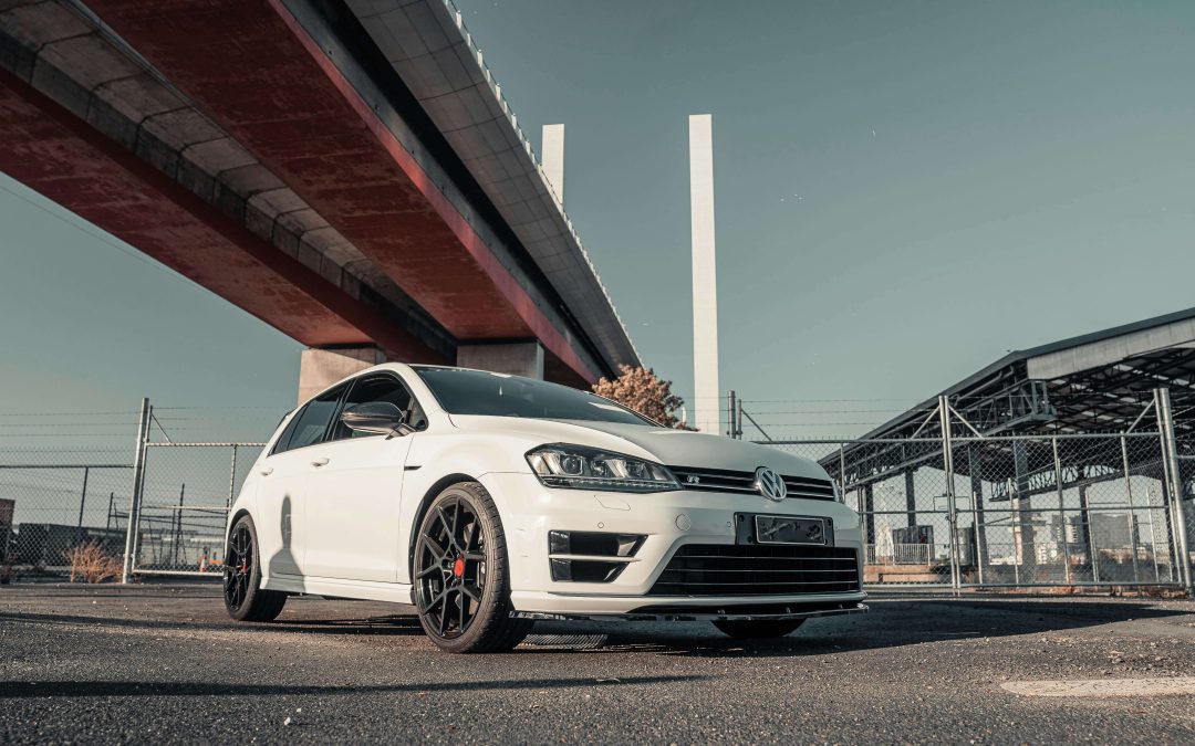 a car parked underneath a bridge in a industrial estate